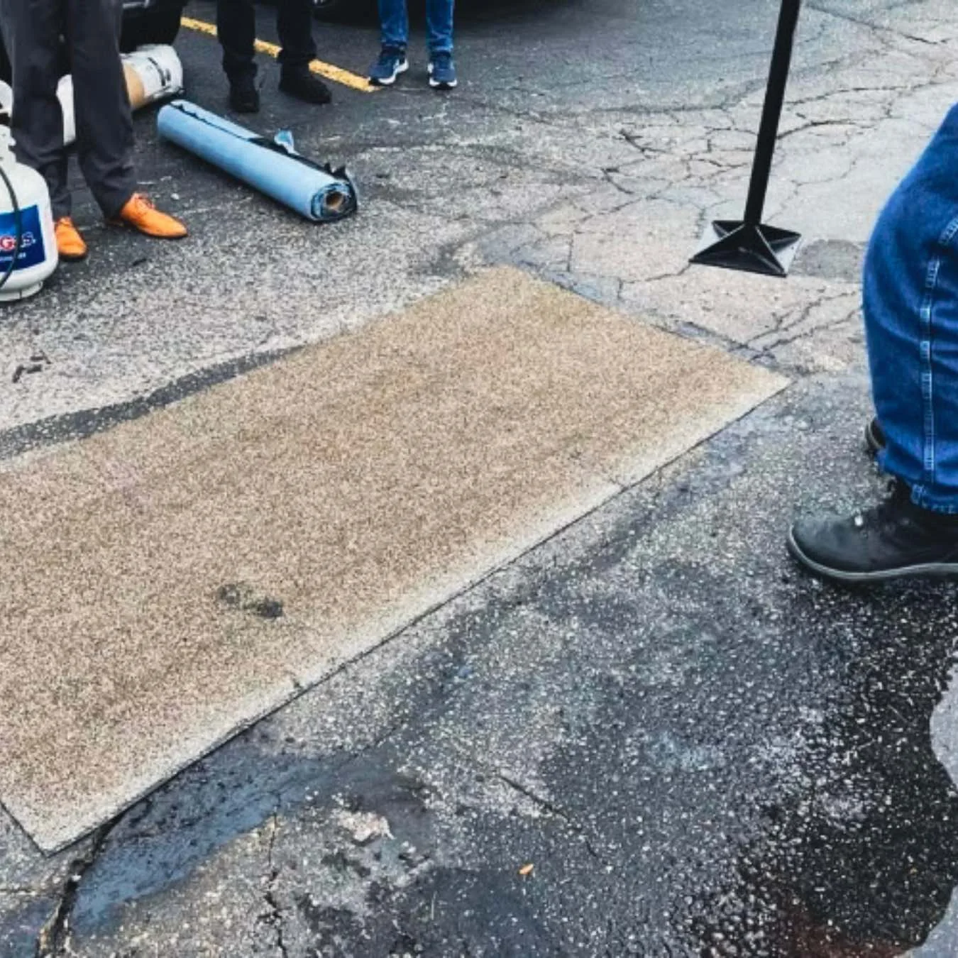 Aplicación de American Road Patch sobre reparación vial, vista editorial.
